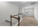 Upstairs hallway with wooden railing and a view of a bright bedroom at 1103 Apogee Dr, Durham, NC 27713