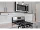 Close up of stainless appliances, granite countertops and tile backsplash at 1123 Latitude Dr, Durham, NC 27713