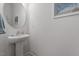 Clean half bathroom featuring a modern pedestal sink and round mirror at 1123 Latitude Dr, Durham, NC 27713