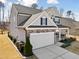 Gray two-story home with a manicured lawn, a two-car garage, and a covered front porch swing at 115 Cliffview Dr, Garner, NC 27529