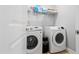 Modern laundry room equipped with Samsung washer, dryer, and convenient shelving for storage at 115 Cliffview Dr, Garner, NC 27529