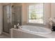 Relaxing bathroom with a soaking tub, walk-in shower, and natural light from the window at 11619 John Allen Road Rd, Raleigh, NC 27614