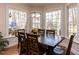 Bright dining room with hardwood floors, large windows, and a wooden table and chairs at 11619 John Allen Road Rd, Raleigh, NC 27614