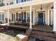 Welcoming front porch with a swing, rocking chairs, and a decorative blue door at 11619 John Allen Road Rd, Raleigh, NC 27614