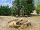 Outdoor fire pit area featuring stone surround, metal grate and two chairs surrounded by trees at 1210 Poplar Forest Lane Ln, Pittsboro, NC 27312