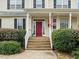 Inviting front entrance with a red door, white porch railing, and manicured landscaping at 1210 Poplar Forest Lane Ln, Pittsboro, NC 27312