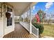 Spacious front porch with wood flooring, white railing, and an American flag at 1210 Poplar Forest Lane Ln, Pittsboro, NC 27312