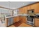 A bright kitchen features stainless steel appliances, wood cabinets, hard wood floors and a dining table at 1210 Poplar Forest Lane Ln, Pittsboro, NC 27312