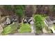 An overhead view of three houses with manicured lawns and mature trees in a suburban neighborhood at 129 Bennett Pl, Clayton, NC 27527