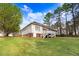 Large backyard with a wooden deck, green grass, and partial view of the home's exterior at 129 Bennett Pl, Clayton, NC 27527