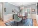 Elegant dining room featuring chandelier, wood table, and stylish blue rug at 129 Bennett Pl, Clayton, NC 27527