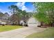 Inviting single-story home with a well-maintained lawn, long driveway, and attached two-car garage at 129 Bennett Pl, Clayton, NC 27527