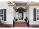 Close-up of the front door with brick steps, black awning, and decorative details at 129 Bennett Pl, Clayton, NC 27527