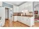 Well-lit kitchen with white cabinets, granite counters, and stainless steel appliances at 129 Bennett Pl, Clayton, NC 27527