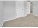 A clean bedroom space featuring neutral carpet, crisp white baseboards, and paneled doors at 1434 Rosepine Dr, Cary, NC 27519