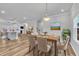 Open dining room featuring hardwood floors, modern lighting, and direct access to the kitchen island at 1434 Rosepine Dr, Cary, NC 27519