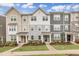 Charming townhome exteriors featuring varied siding and manicured lawns set against a bright, partly cloudy sky at 1434 Rosepine Dr, Cary, NC 27519