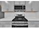 This kitchen features stainless steel appliances, a gas range, and stylish gray cabinetry with white subway tile at 1434 Rosepine Dr, Cary, NC 27519