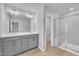 Main bathroom featuring double vanity sinks, a large mirror, and glass-enclosed shower at 1434 Rosepine Dr, Cary, NC 27519