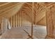 An unfinished attic shows the frame with bare wood walls, floor, and support beams, offering potential for a custom build at 147 Tralee Dr, Smithfield, NC 27577