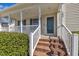 Inviting front porch with classic brick steps and white railing, leading to the front door at 147 Tralee Dr, Smithfield, NC 27577