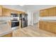 This kitchen features wooden cabinets, stainless steel appliances, a light countertop, and modern flooring with a seamless flow at 147 Tralee Dr, Smithfield, NC 27577