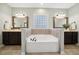 Bright bathroom featuring a soaking tub between two vanities with dark wood cabinets at 153 Brindley Cir, Clayton, NC 27520