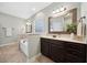 Bright bathroom featuring a soaking tub, framed mirror, and dark wood cabinets at 153 Brindley Cir, Clayton, NC 27520