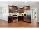 Updated kitchen featuring stainless steel appliances, dark cabinetry, and modern lighting fixtures at 153 Brindley Cir, Clayton, NC 27520