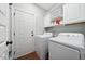 Laundry room features a washer, dryer, and white cabinets for storage at 153 Brindley Cir, Clayton, NC 27520