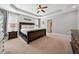 Main bedroom features a tray ceiling, ceiling fan, carpeted floors, and natural light at 153 Brindley Cir, Clayton, NC 27520