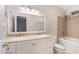 Bright bathroom features a double sink vanity, framed mirrors, tub with shower, and neutral tile at 1603 Stonegate S, Sanford, NC 27332