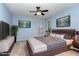 Comfortable bedroom with a ceiling fan, two windows, and stylish decor creating a relaxing atmosphere at 1603 Stonegate S, Sanford, NC 27332
