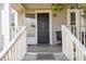 Inviting front porch featuring a black door, open sidelight, and weathered white railings at 1614 Homewood Ave, Durham, NC 27707