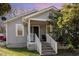 Charming home featuring light gray siding, white trim, and a welcoming front porch with steps and chair at 1614 Homewood Ave, Durham, NC 27707