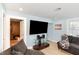 Comfortable living room featuring light blue walls, light colored floors, and a large flat screen television at 1614 Homewood Ave, Durham, NC 27707