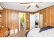 Bedroom with wood paneled walls and ceiling fan features doors to a bathroom and another room at 1614 Homewood Ave, Durham, NC 27707