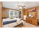 Bedroom with wood paneled walls and ceiling fan features large dresser and an open closet at 1614 Homewood Ave, Durham, NC 27707