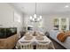 Bright dining room featuring neutral tones, a modern chandelier, and a large window at 1628 Highpoint St, Wake Forest, NC 27587