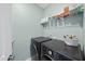 Spacious laundry room with modern washer and dryer, plus shelving for storage at 1628 Highpoint St, Wake Forest, NC 27587