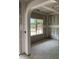 Living room featuring an archway and a large window overlooking the yard and unfinished walls at 200 Dove Rd, Cameron, NC 28326