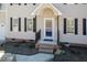 Close up of home's front entry with a storm door and brick stairs surrounded by new landscaping at 244 Victor Ct, Garner, NC 27529