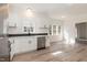 Modern kitchen with white cabinetry, stainless steel dishwasher, and three windows offering ample natural light at 244 Victor Ct, Garner, NC 27529
