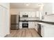 Modern kitchen with white cabinetry, stainless steel appliances, light countertops, and a large refrigerator at 244 Victor Ct, Garner, NC 27529