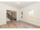 Spacious living room with large windows, light-colored floors, and access to other areas of the home at 244 Victor Ct, Garner, NC 27529
