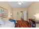 Bright bedroom with hardwood floors, a cozy bed, and a hallway view at 2524 Forest Shadows Ln, Raleigh, NC 27614