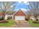 Charming brick home featuring an attached garage, inviting entrance, and manicured lawn at 2524 Forest Shadows Ln, Raleigh, NC 27614
