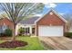 Charming brick home with a two-car garage, manicured lawn, and blossoming trees at 2524 Forest Shadows Ln, Raleigh, NC 27614