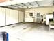 Spacious garage featuring built-in storage cabinets, utility sink, and shelving for organization and convenience at 2524 Forest Shadows Ln, Raleigh, NC 27614