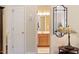 Hallway view of a bathroom featuring a white door and a decorative table lamp with an elegant shade at 2524 Forest Shadows Ln, Raleigh, NC 27614